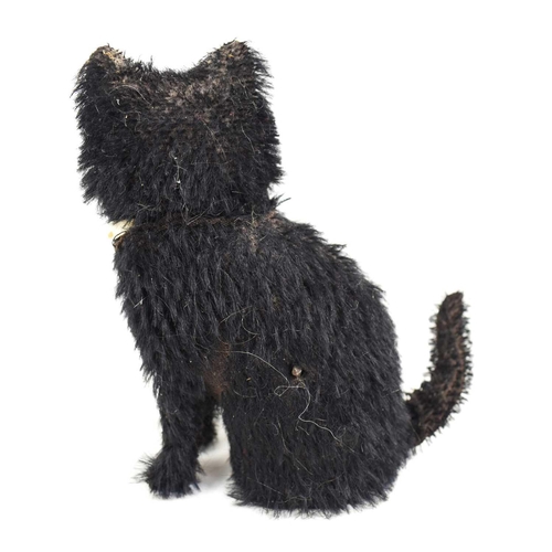 72 - A small vintage automaton black cat, with glass eyes, and cream silk bow, winding hole to the back, ... 