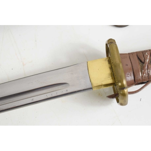 105 - A Japanese WWII NCO shin gunto sword, with brass shaped and pebbled tsuba above arsenal marks and re... 