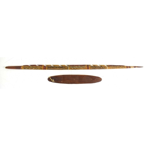115 - An aboriginal barbed painted spear, 80cm, together with an aboriginal engraved bullroarer, 29cm long... 