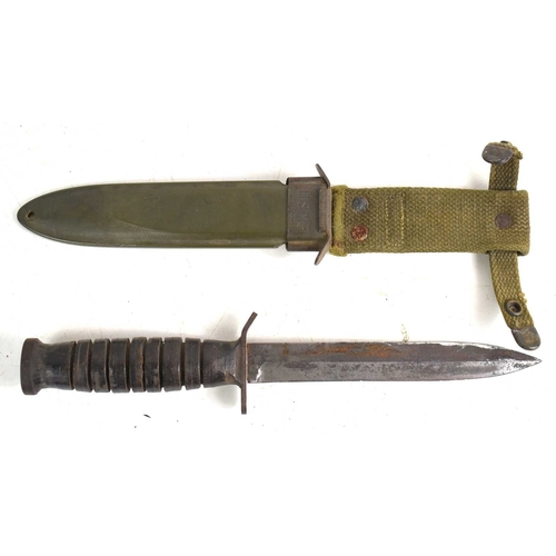 71 - A US WWII era M3 fighting knife, the hilt stamped with the flaming bomb proof mark, house in a US M8... 