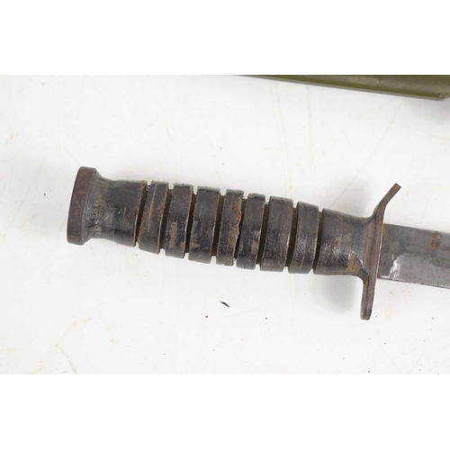 71 - A US WWII era M3 fighting knife, the hilt stamped with the flaming bomb proof mark, house in a US M8... 