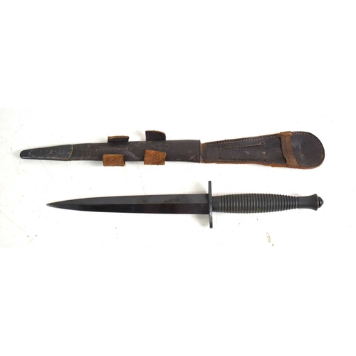 73 - A British Commando Fairbairn Sykes style fighting knife with leather scabbard, the knife is stamped ... 