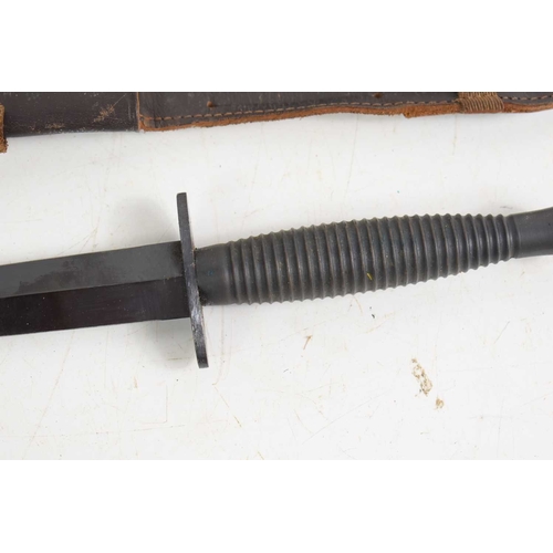 73 - A British Commando Fairbairn Sykes style fighting knife with leather scabbard, the knife is stamped ... 