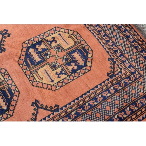 316 - An antique Middle Eastern wool rug, with orange ground and repeating foliate and geometric border wi... 