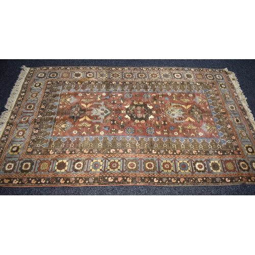 318 - A Turkish wool rug, red ground with traditional geometric motifs and a central medallion design, 240... 