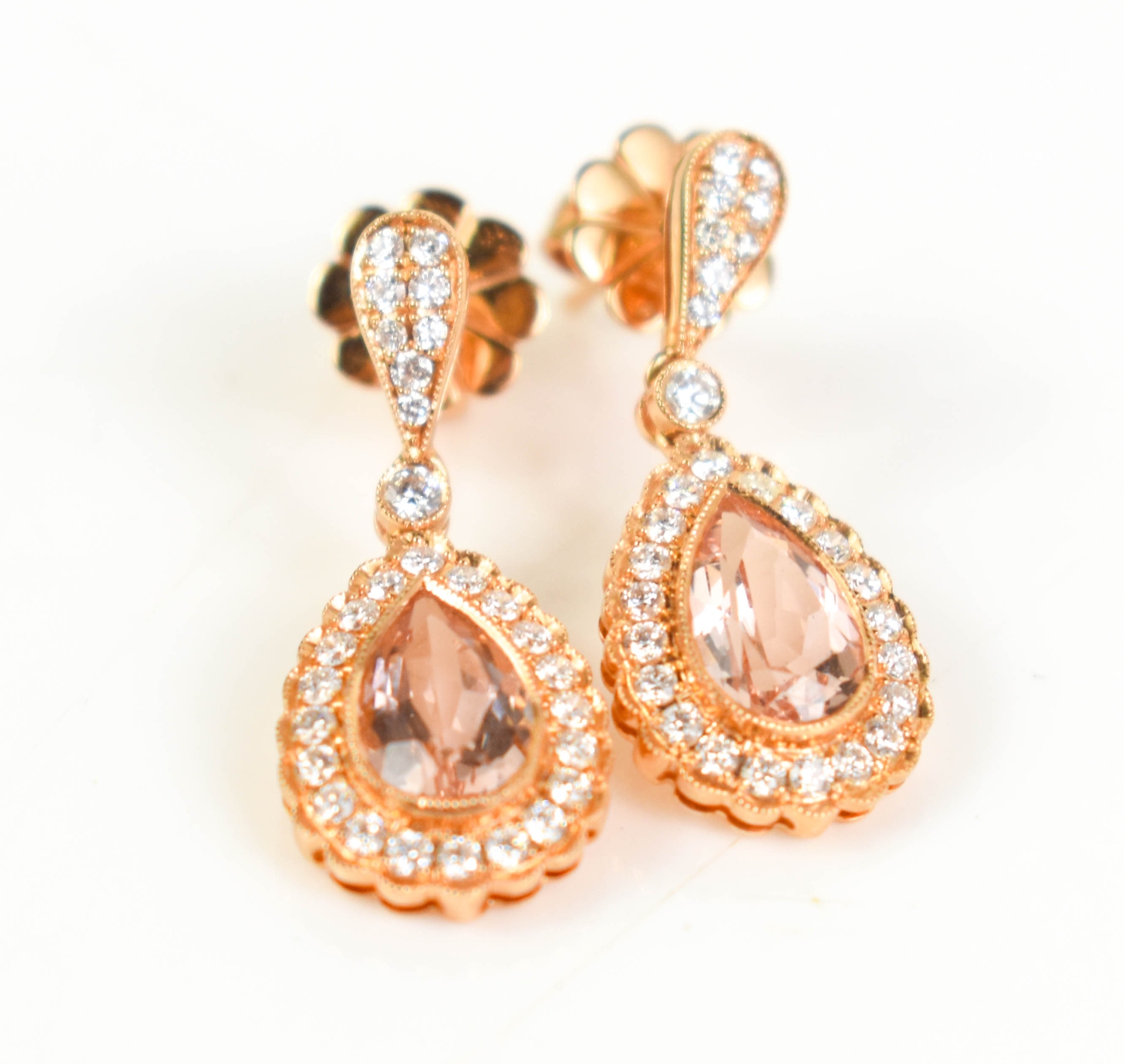 A pair of 18ct gold drop earrings with a pear cut peach morganite ...