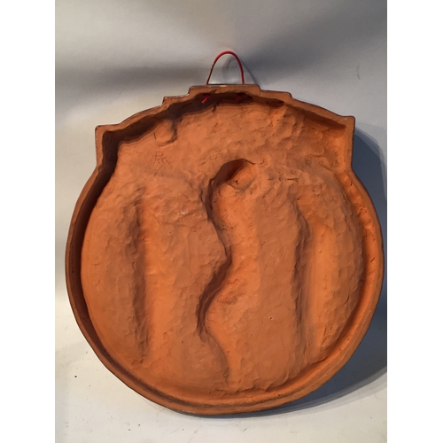 101 - Terracotta glazed corpus Christie round wall plaque. Measures 45 x 41 cm