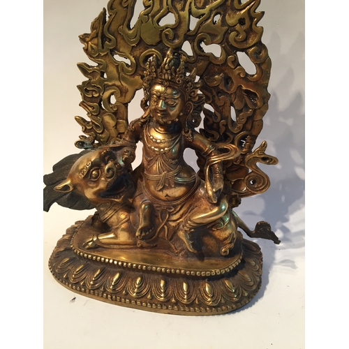 225 - Bronze Gilt God Sat On A Foo Dog. 26 high x 18cms