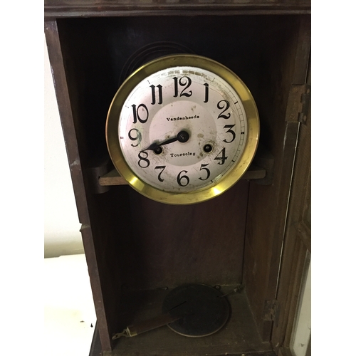 328 - Cased wall vandeneheed touroing clock with pendulum measures 53 x 28 cm