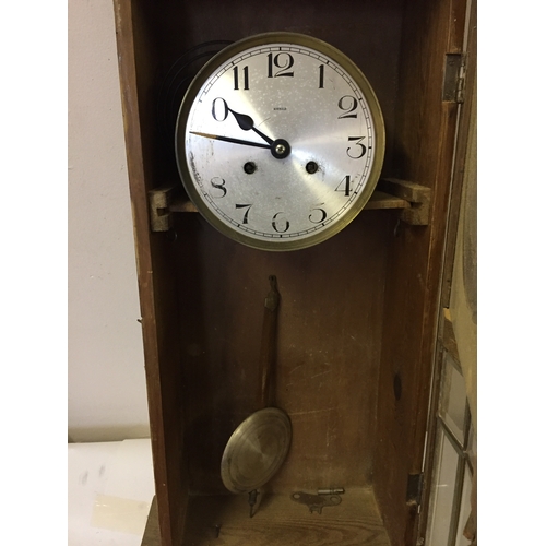 337 - Cased wall clock with pendulum measures 84 x 35 cm