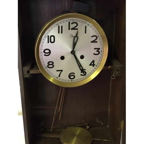 349 - Cased wall clock with pendulum measures 59 x 33 cm