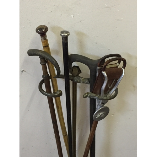 106 - Antique Bronze Stick Stand Along With A Selection Of Sticks To Include Silver Top Stick Etc.