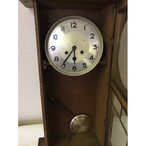 56 - Cased wall clock with pendulum measures 79 x 35 cm