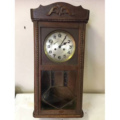 42 - Cased wall clock with pendulum measures 75 x 32 cm