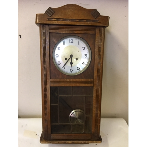 45 - Cased wall clock with pendulum measures 79 x 35 cm