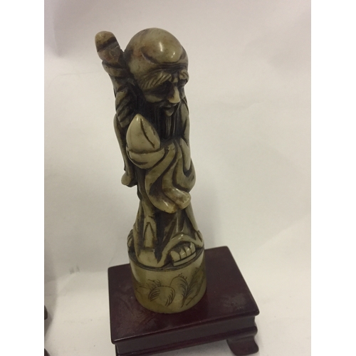 213 - A Rootwood Figure Of An Immortal Along With A Soapstone  Figure On A Wood Plinth.