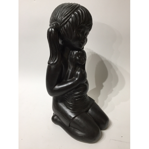 184 - Signed statue of a girl holding a doll 45cm tall