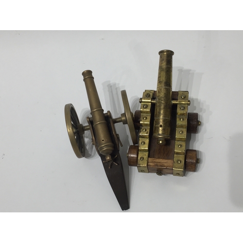 162 - Two miniature cannons one on wooden base one on brass wheels largest being 17cms long