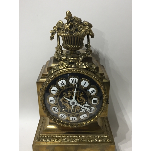 296 - Ormolu  Mantle Clock With Enamel Dials And A Floral Finial With Key And Pendulum. 29cms High