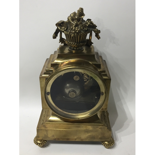 296 - Ormolu  Mantle Clock With Enamel Dials And A Floral Finial With Key And Pendulum. 29cms High