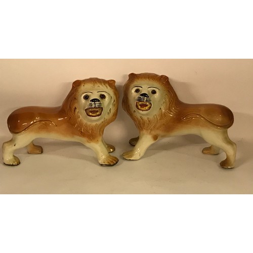 131 - Pair Of Ceramic Lion Figures One Leg Has Been Glued. 36 x 26 cms High