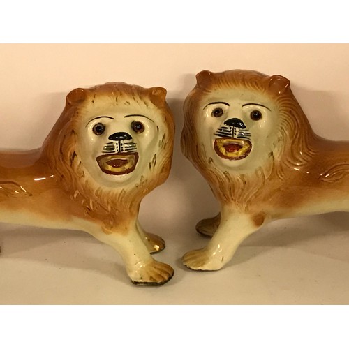 131 - Pair Of Ceramic Lion Figures One Leg Has Been Glued. 36 x 26 cms High