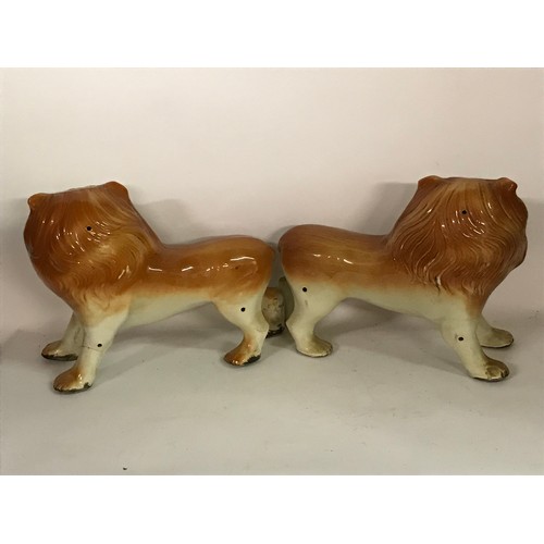 131 - Pair Of Ceramic Lion Figures One Leg Has Been Glued. 36 x 26 cms High