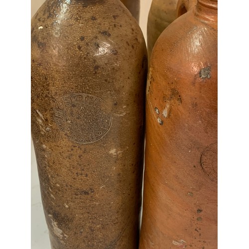 353 - Four Antique Stoneware Gin Bottles. One Handle Missing  30 cms High (4)