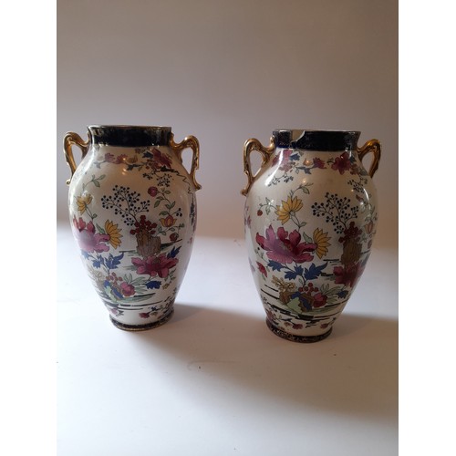 24 - Pair of PHEONIX WARE vases hand painted with wear to gilding and damage to rim of one. 24cm tall