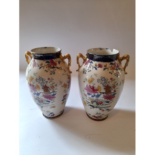 24 - Pair of PHEONIX WARE vases hand painted with wear to gilding and damage to rim of one. 24cm tall