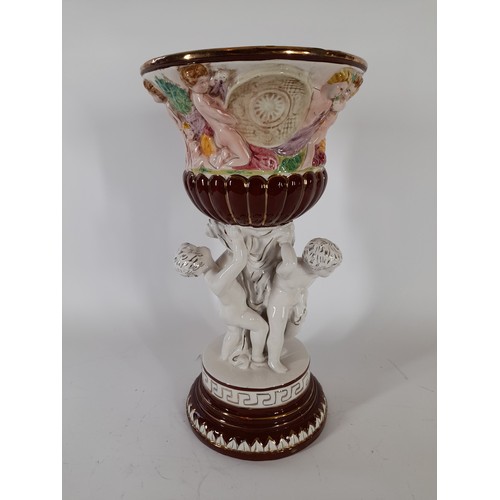 56 - Italian made ceramic centre piece depicting Cherubs hlding up an urn ,37cm high