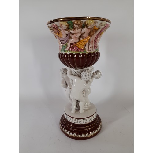 56 - Italian made ceramic centre piece depicting Cherubs hlding up an urn ,37cm high