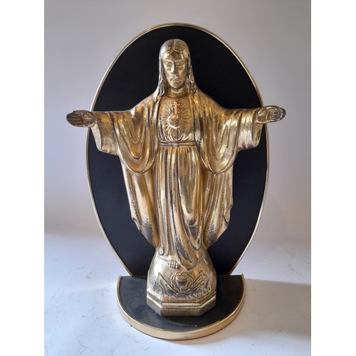 259 - Brass coloured spelter Sacred Heart with open arm on wooden plinth,  33cm x 23cm