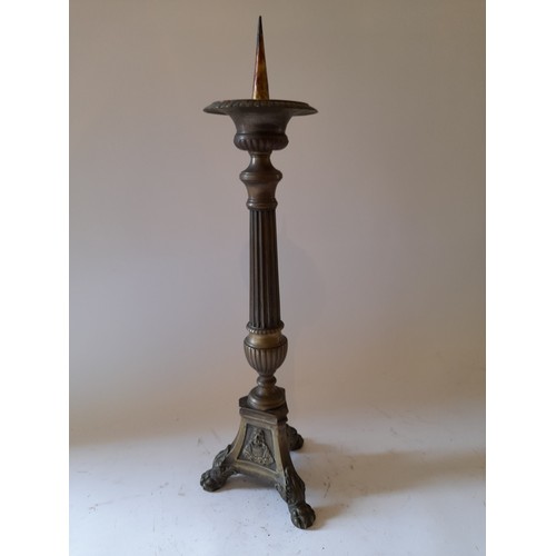 263 - Tall brass pricket candle stick standing on 3 paw feet. 52cm high