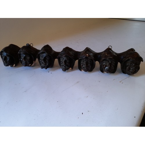 266 - Plaster Pipe rack in the form of 7 faces 49cm long, some chips