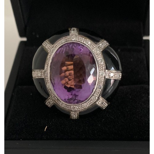 352 - 18ct Gold Ring Having A Large Amethyst In Jet With Diamond Decoration
15.6g. Size P