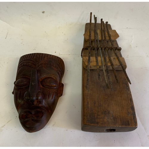 133 - Vintage Tribal Instrument Together With A Carved Tribal Mask
21 x 8 cms and mask 13 x 8 cms