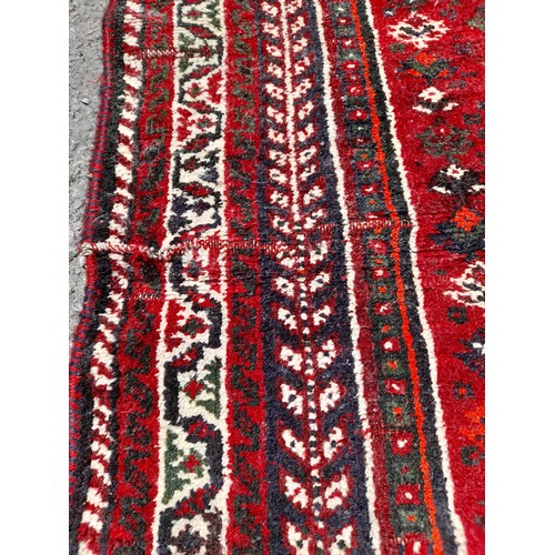 88 - Red Ground Handmade Rug with repairs, 148cm x 114cm