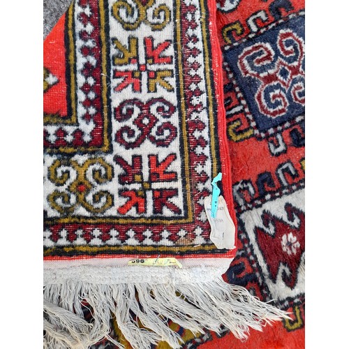 75 - Handmade Rug. Red Ground with central Lozenges. 200CM X 133