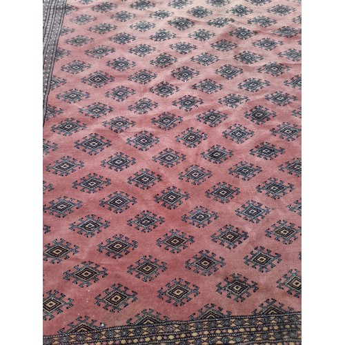 77 - Handmade large Pink ground Rug with diamond pattern to centre. 276cm x 189cm