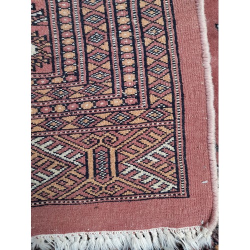 77 - Handmade large Pink ground Rug with diamond pattern to centre. 276cm x 189cm