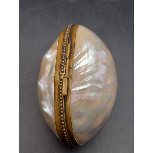 353 - An Egg Shaped Box of Mother of Pearl opening up to reveal a Micro Mosaic Cross with Brass Back 5cm l... 