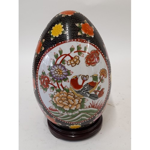 113 - Large Ceramic Satsuma EGG with Bird decoration to both sides on wooden stand, 29cm high