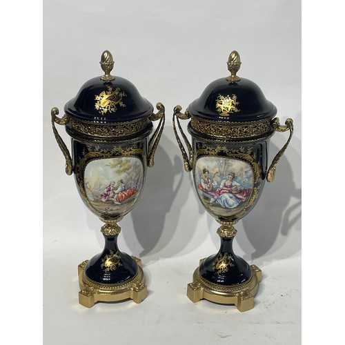 309 - A Pair of Serves Marked Porcelain Urns 43cm high with romantic scenes on each