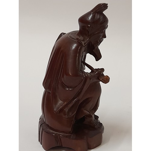 223 - Wood Carved Oriental Immortal smoking a pipe, 13cm high