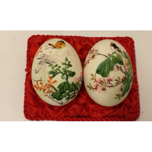 782 - 3 x hand painted eggs with 2 x Ceramic hand painted eggs on a fabric mount. (5)