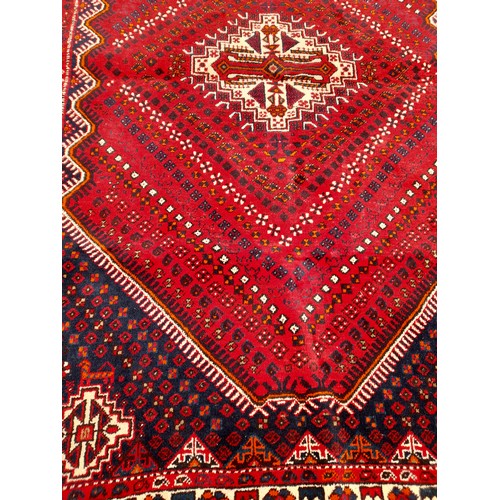 80 - Red Ground Hand knotted Rug With geometric design within a large Medallion, 290cm x 197cm