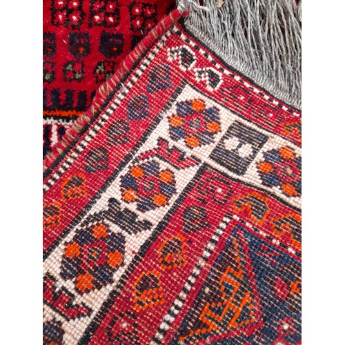 80 - Red Ground Hand knotted Rug With geometric design within a large Medallion, 290cm x 197cm