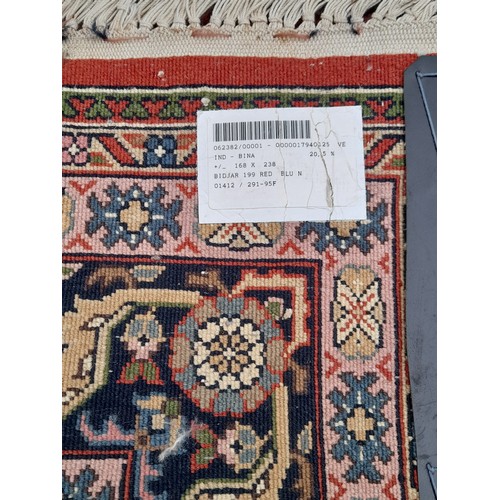 52 - Red ground hand knotted Rug with multi colour Lozenge to centre, 243cm x 170cm