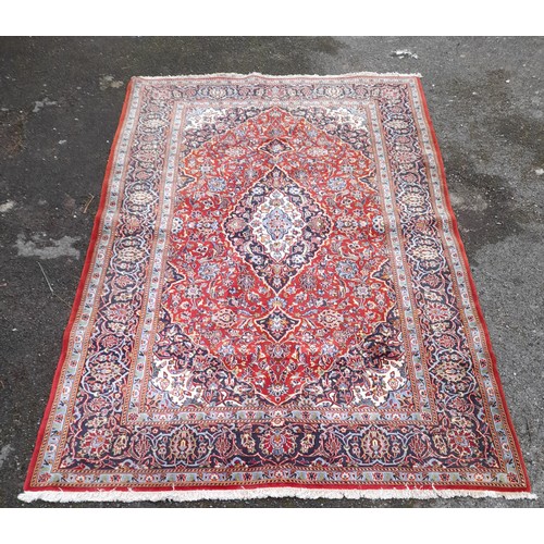 54 - Red Ground Rug with Blue central Diamond design, 228cm x 145cm